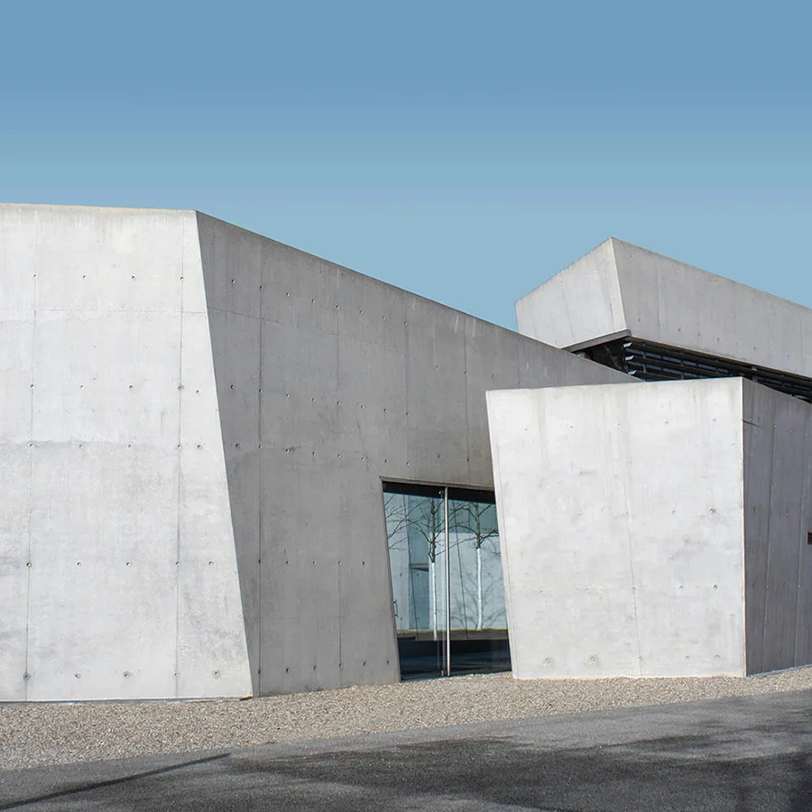 Maison minimaliste construite en béton gris, finition béton banché.