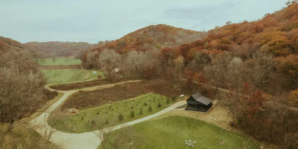 Vue aérienne d'une vallée automnale avec son chalet en bois foncé.