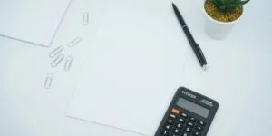 feuille avec calculatrice et stylo