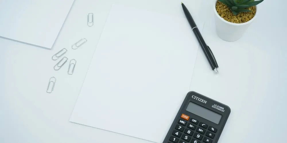 feuille avec calculatrice et stylo